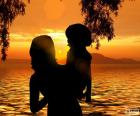 Мама с сыном на руках, глядя на великолепный закат на озере